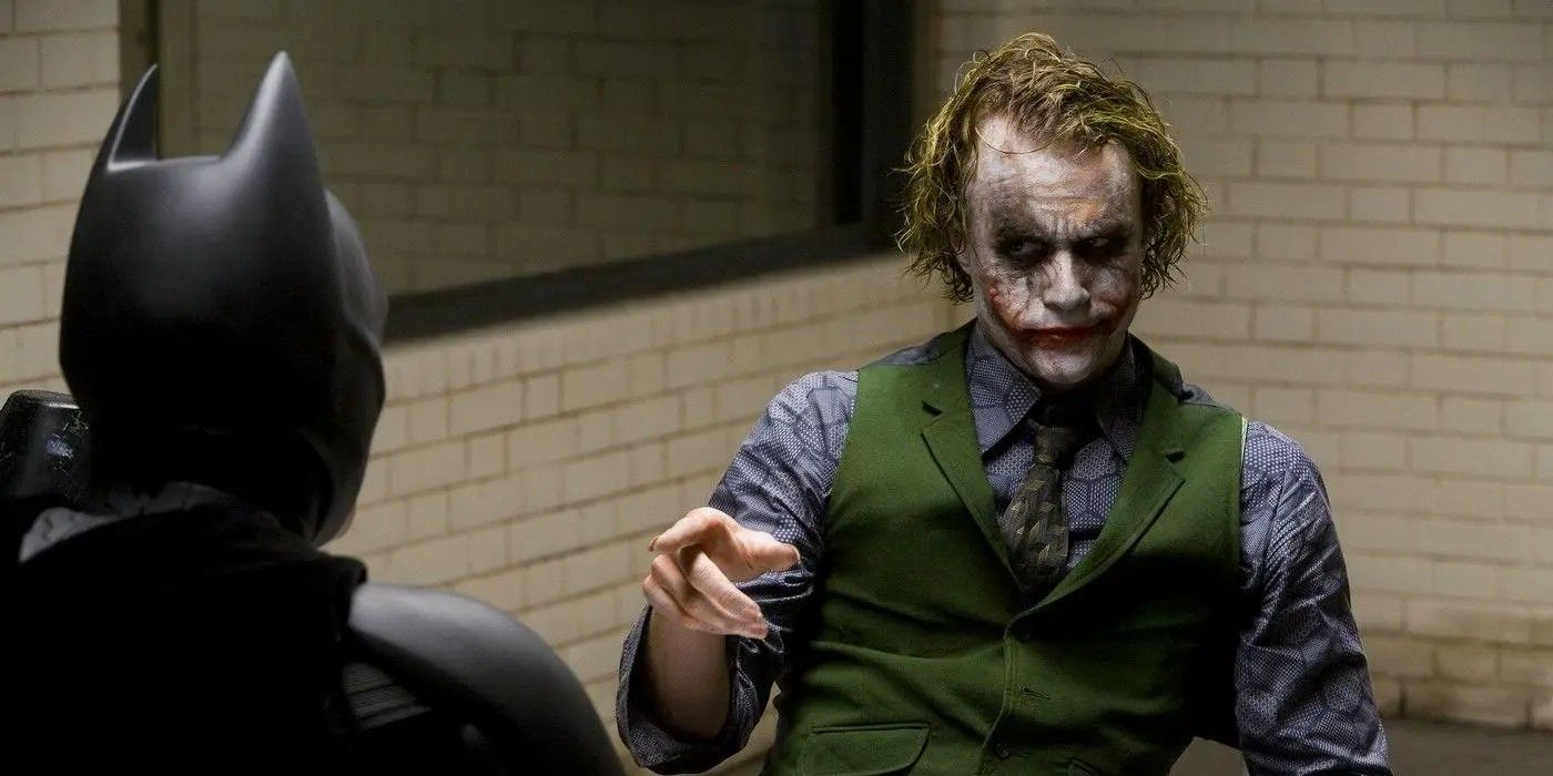 Хит Леджер в роли Джокера указывает на Бэтмена Кристиана Бэйла в фильме "Темный рыцарь"