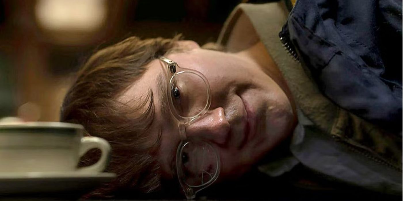 Загадник, якого грає Пол Дано, усміхається, притулившись головою до стійки під час сцени арешту у фільмі "Бетмен"
