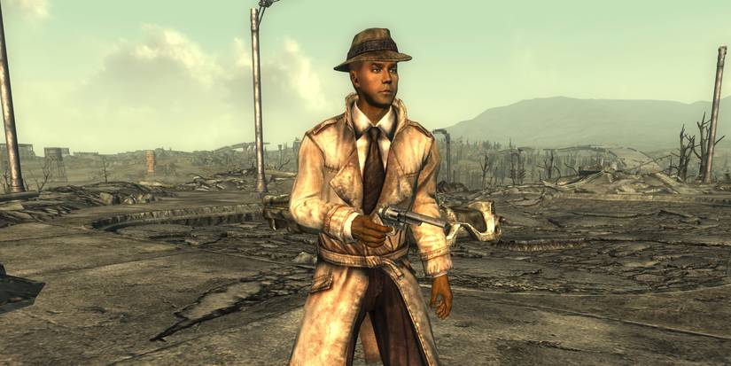 Таємничий Незнайомець, як він з'являється у Fallout 3 та New Vegas, стоїть на руїнах вулиці та цілить з пістолета.