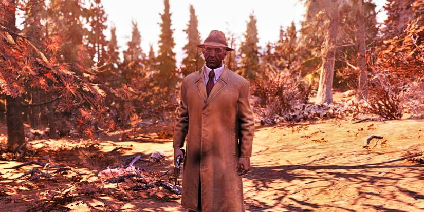 Таємний Незнайомець, чоловік у плащі з револьвером на стороні, стоїть у лісі на знімку екрана з «Фолаут 4».