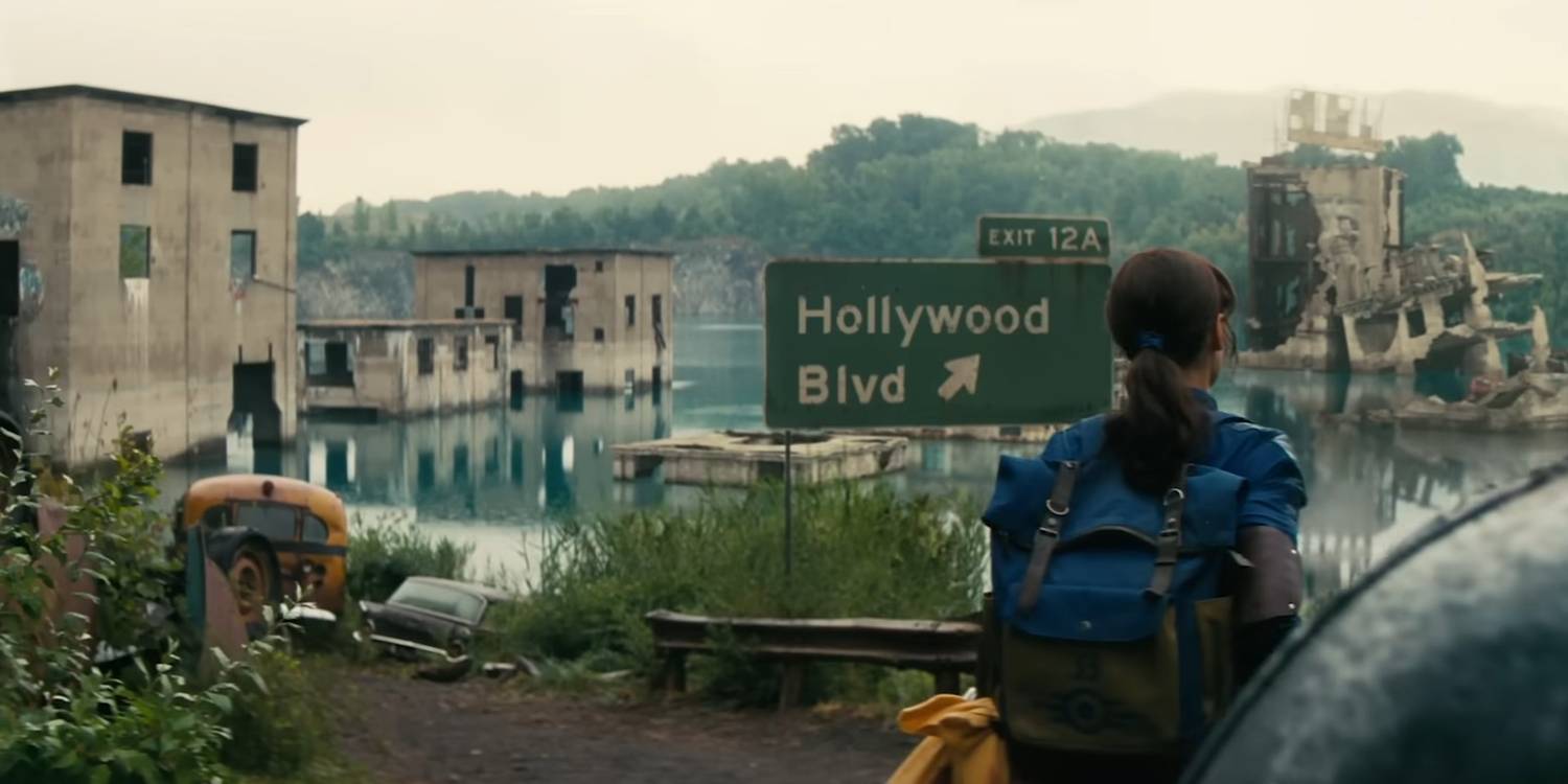 Люсі проходить повз затоплене, зруйноване місто та дорожній знак, на якому написано "Hollywood Blvd" у Фолауті